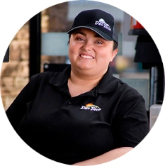 Portrait photo of a Del Taco Assistant General Manager. She is at work wearing a Del Taco branded cap and polo.