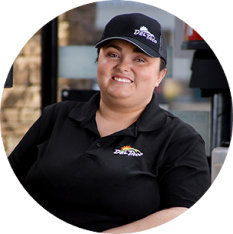 Portrait photo of a Del Taco Assistant General Manager. She is at work wearing a Del Taco branded cap and polo.